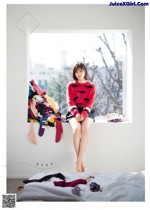 Risa Watanabe 渡邉理佐, Shonen Magazine 2019 No.12 (少年マガジン 2019年12号) A woman sitting on top of a bed next to a window.