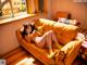 A woman laying on a yellow couch in a room.