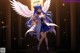 Anime girl with white wings standing in a dark room.