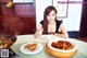A woman sitting at a table with a bowl of food.
