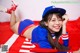 A woman in a baseball uniform laying on a red blanket.