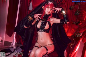 A woman in a black and red outfit posing for a picture.