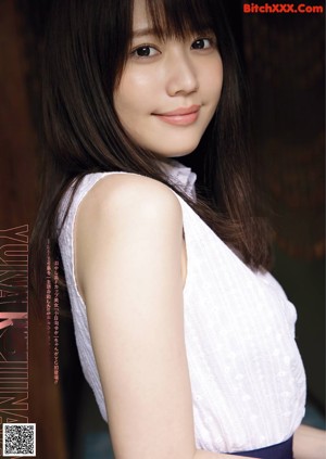 A woman in a white top and blue skirt posing for a magazine.
