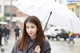 A woman holding a white umbrella in the rain.