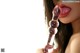 A woman holding a pink dildo in her mouth.