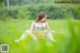 A woman sitting in a field of green grass.