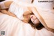 A woman laying on a bed in a white lingerie.